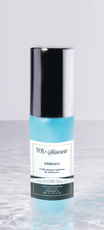 Blue Tox & Skincare Drench hydrating serum bottle on a reflective surface.