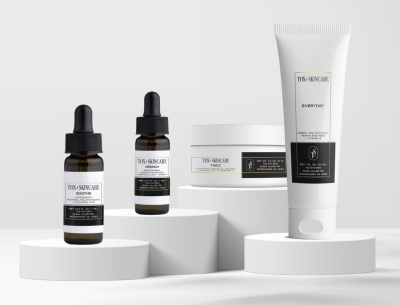 Tox Skincare products on display including serums and creams on white podiums.